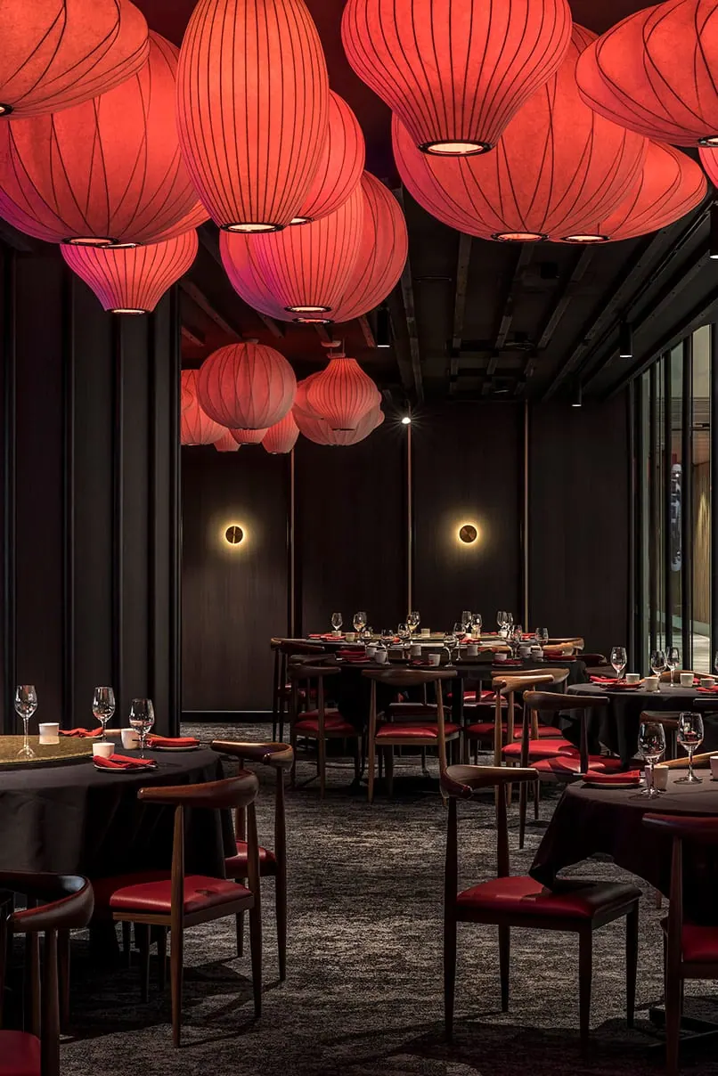 布里斯班喜凤台用餐区，天花板挂满红色灯笼，圆桌配红色座椅