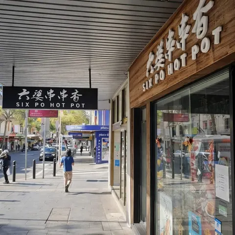 六婆串串香 Burwood 门店外观，木质门头上有“六婆串串香 SIX PO HOT POT”中英文招牌